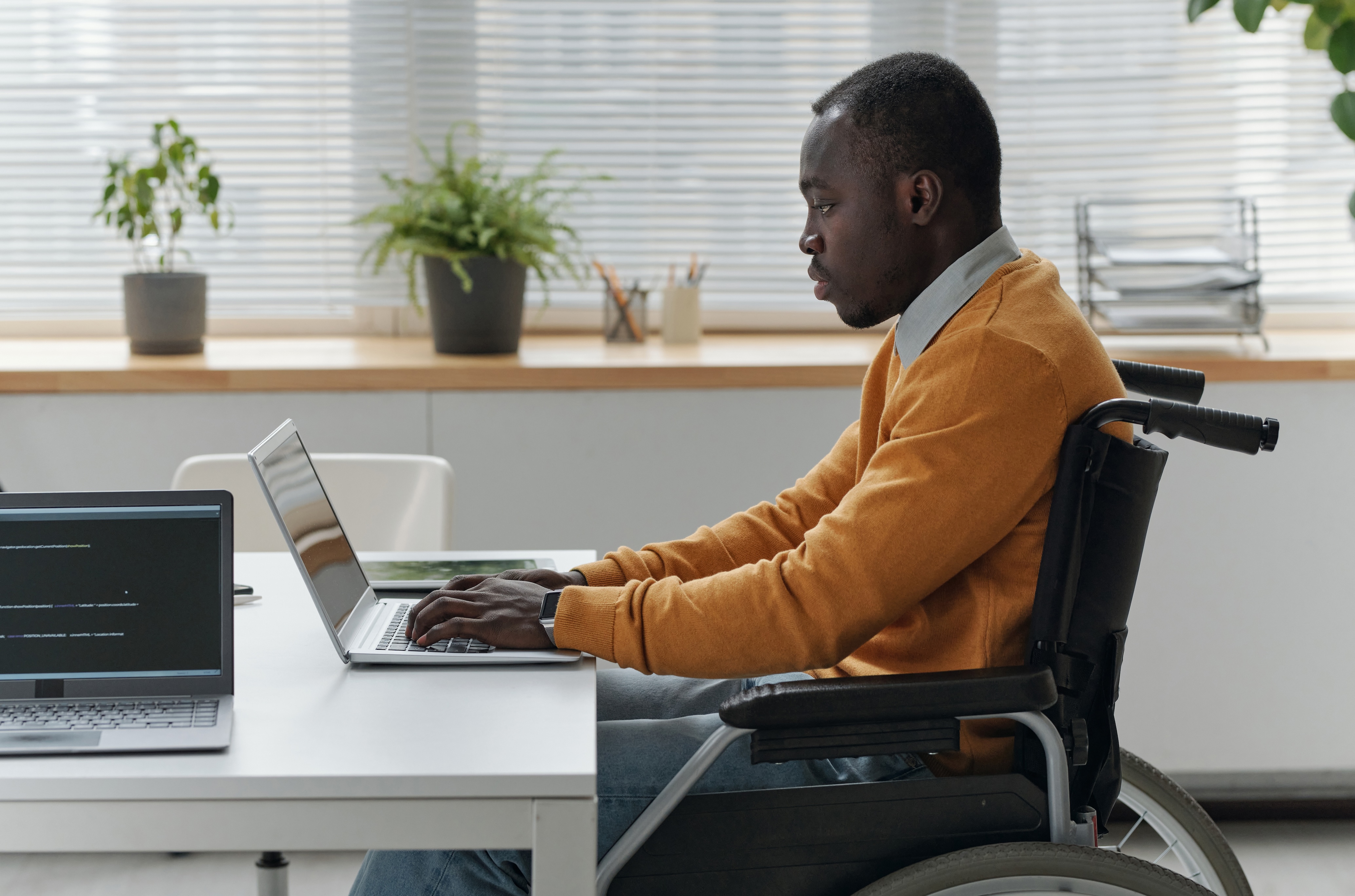 Tired-looking man working on laptop, without Crowdalert to reduce the workload and noise from constant alerts