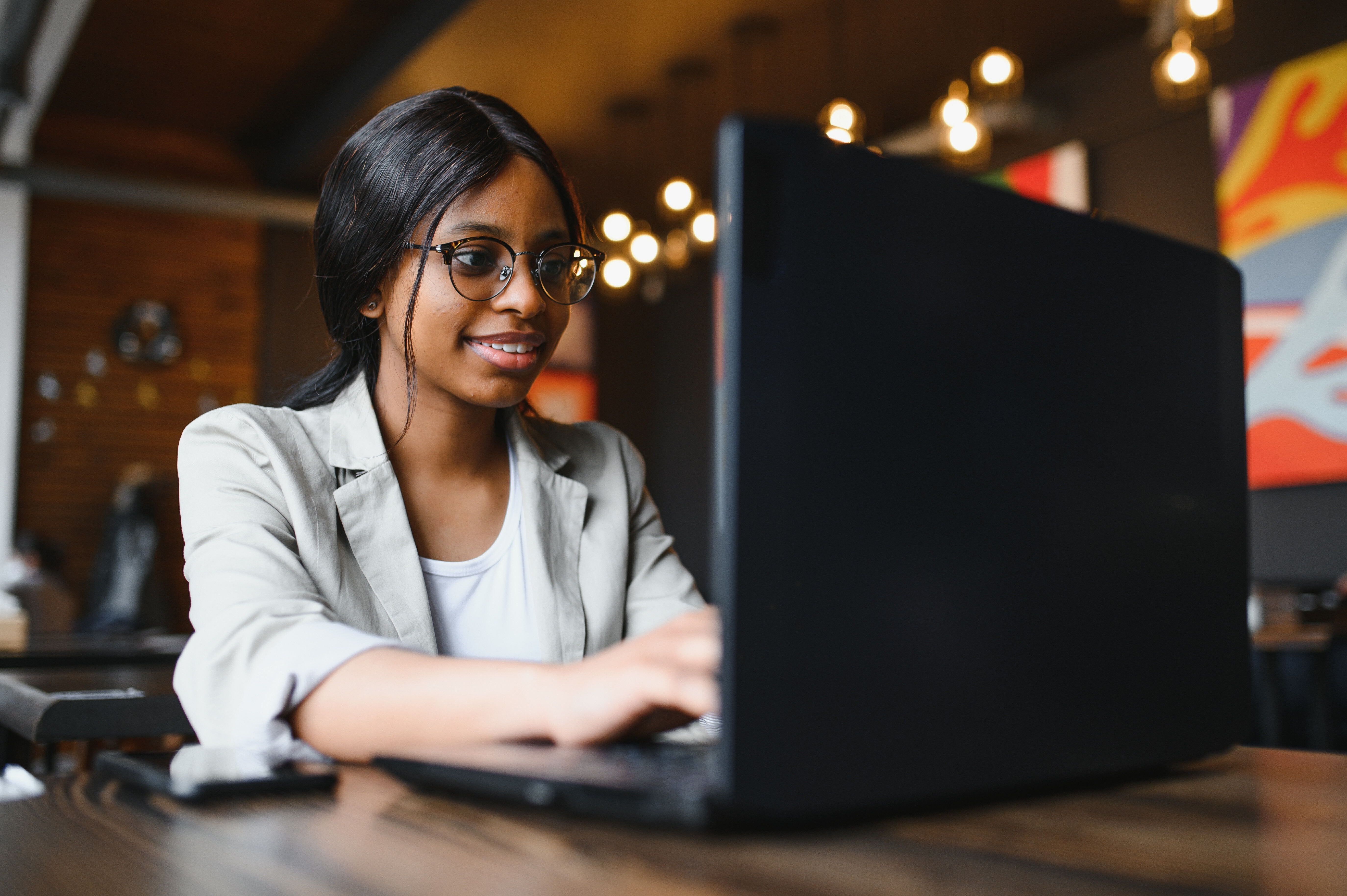 Woman smiling at her laptop, showing how Crowdalert delivers the right real-time security alerts to keep you informed and in control