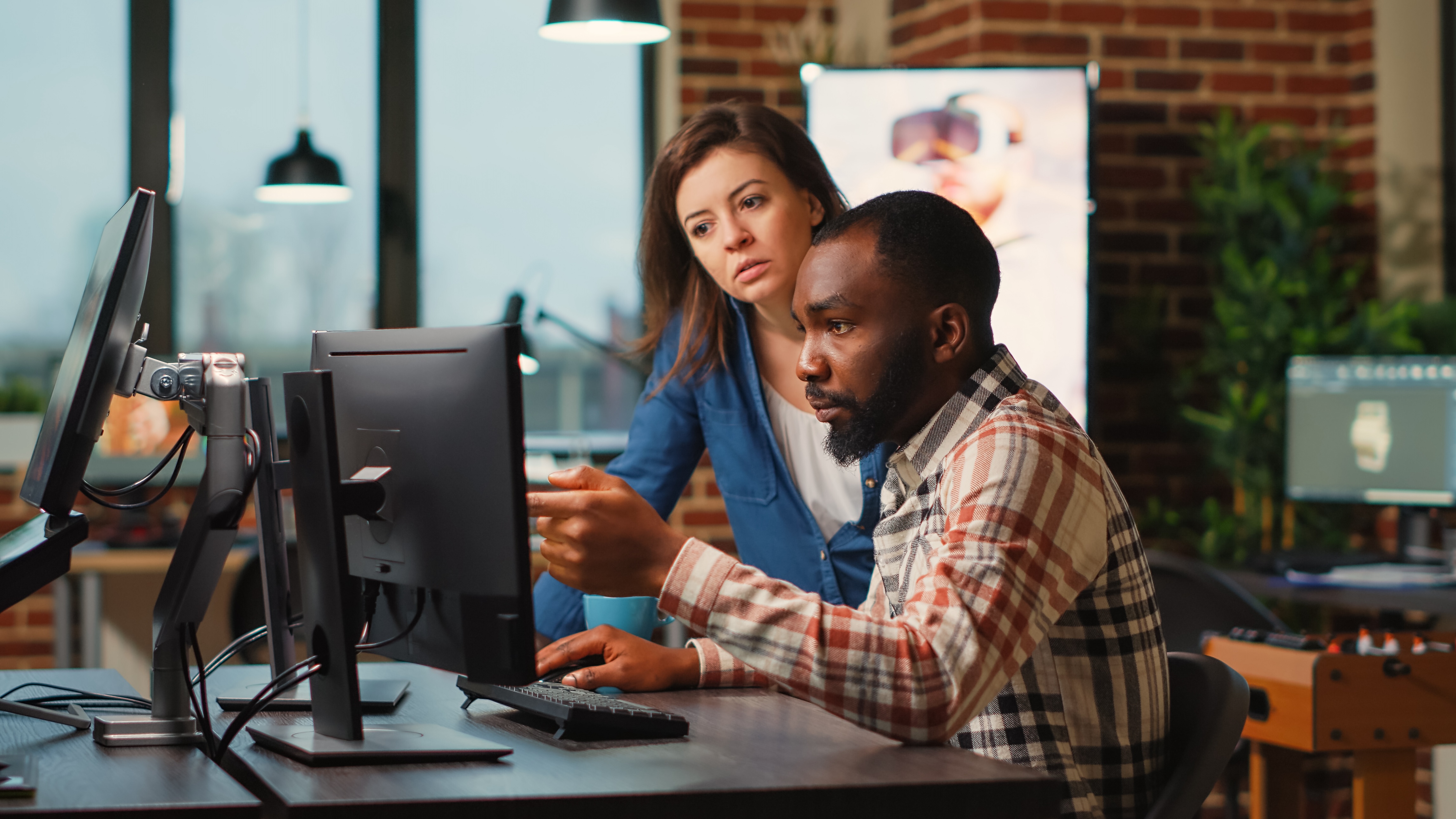 Man and woman reviewing security data on a monitor, illustrating how effective alert management reduces time spent in security consoles