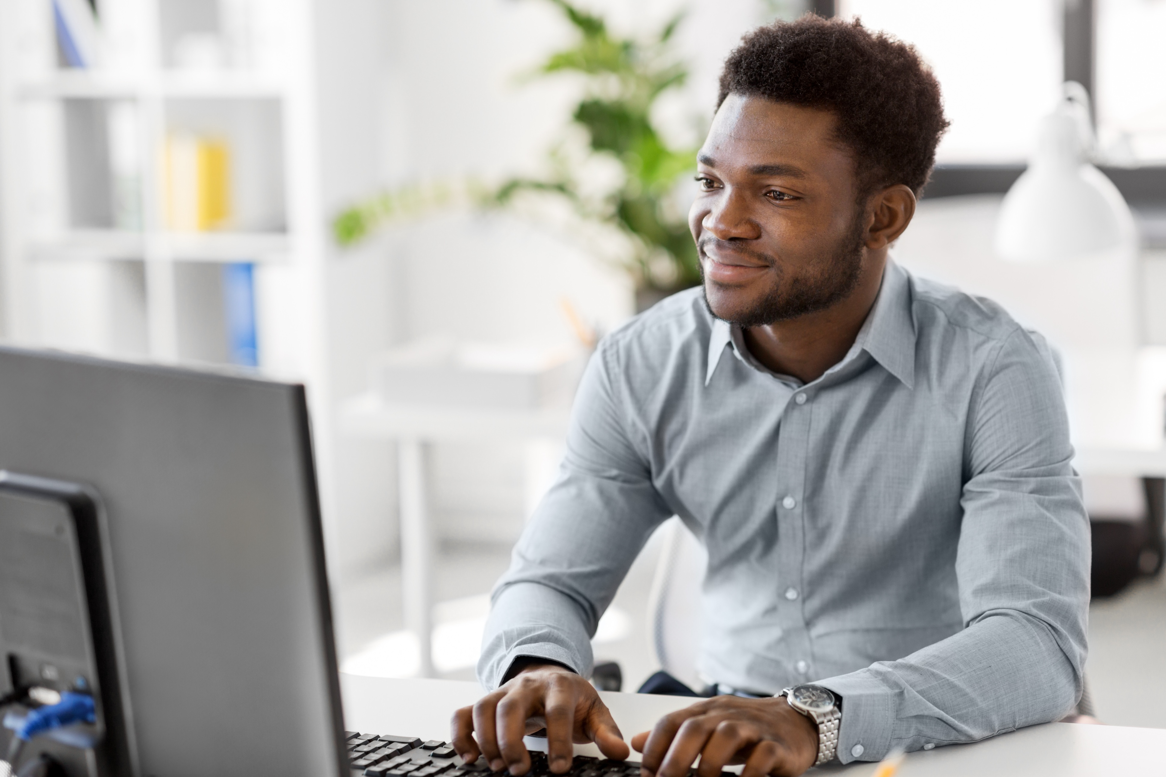 Man smiling while working on his computer, showing how Crowdalert filters through noise to deliver the most important security messages