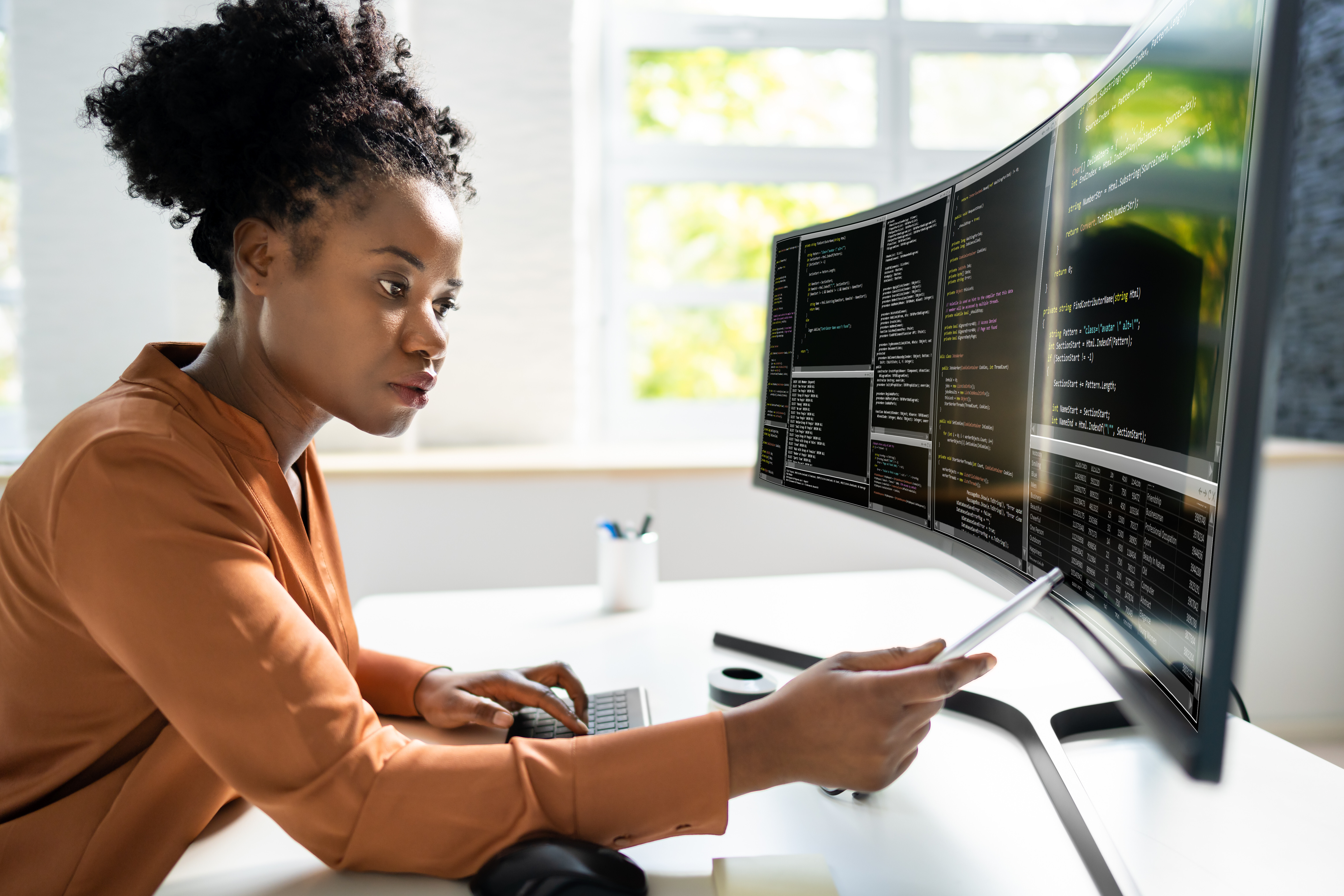 Woman analyzing security data on a large monitor, demonstrating how Crowdalert reduces information overload and prioritizes critical alerts in security operations