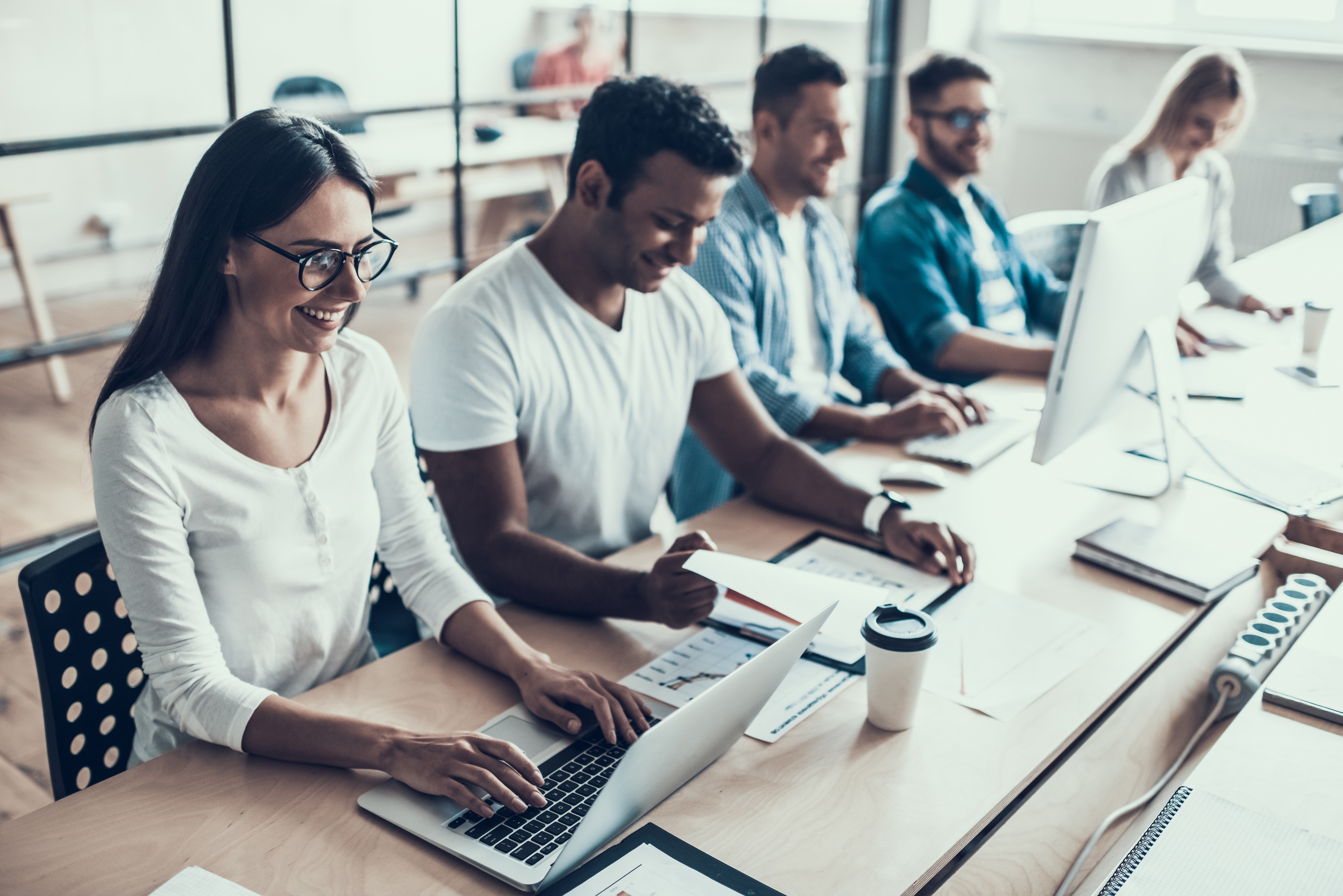 Diverse team collaborating on computers, demonstrating how tools can seamlessly support both security teams and developers in their workflows